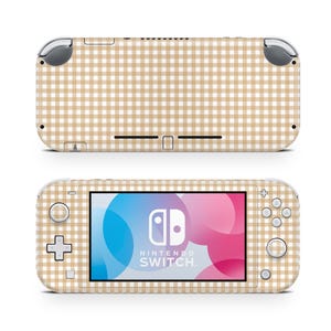 Puede incluir: Una consola Nintendo Switch Lite con un patrón de cuadros beige y blanco. La pantalla muestra el logotipo de Nintendo Switch. La consola se muestra desde la parte delantera y trasera.