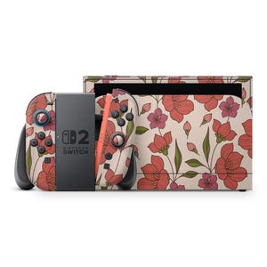 Peut inclure: Une console Nintendo Switch et ses manettes avec un motif floral. Le motif présente des fleurs rouges et roses avec des feuilles vertes sur un fond crème. La console et les manettes sont présentées sur un fond blanc.