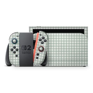 Può includere: Una console Nintendo Switch e controller con un motivo a quadretti verde e bianco. I controller hanno pulsanti neri e dettagli rossi. La console è in posizione verticale.