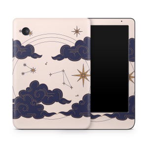 Könnte beinhalten: Eine cremefarbene Tablet-Hülle mit einem Himmelsdesign. Dunkelblaue Wolken, goldene Sterne und Sternbilder sind um eine goldene Windrose und einen kreisförmigen Bogen angeordnet. Der Tablet-Bildschirm ist schwarz.