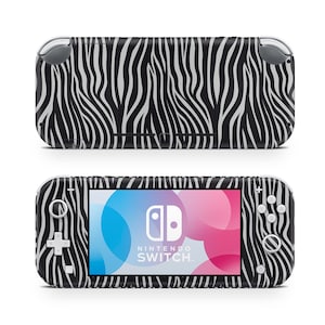 May include: A black and white zebra-striped Nintendo Switch Lite console. The handheld gaming device has a screen showing the Nintendo Switch logo and colourful graphics. The design covers the entire console, including the buttons and controls.