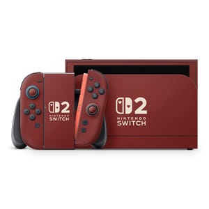 Könnte beinhalten: Eine maroonfarbene Nintendo Switch-Konsole mit passenden Joy-Con-Controllern. Die Controller haben schwarze Knöpfe und blaue und orangefarbene Akzente. Die Konsole und die Controller tragen den Text "Nintendo Switch" und ein stilisiertes Logo.
