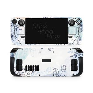 Peut inclure: Une peau pour Steam Deck avec un motif floral aux accents aquarelles bleus et blancs. La peau recouvre l'avant et l'arrière de l'appareil de jeu portable. Le texte "Stick It And Play" est visible sur l'écran.
