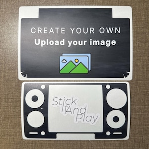 Puede incluir: Dos pegatinas en blanco y negro. La pegatina superior tiene el texto "CREATE YOUR OWN Upload your image" y un gráfico de una montaña y un sol. La pegatina inferior dice "Stick And Play" en una fuente estilizada.