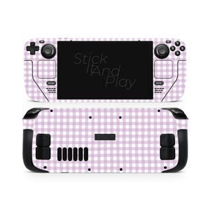 May include: A Steam Deck console skin with a light purple and white gingham design. The skin covers the front and back of the device, with the text "Stick It And Play" visible on the screen. The console has black control buttons and a black screen.