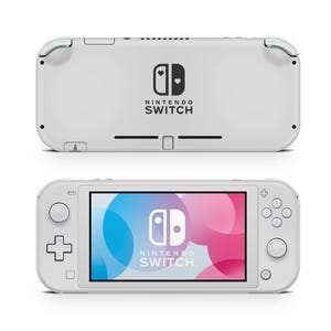 Puede incluir: Una consola Nintendo Switch Lite blanca, mostrada desde la parte delantera y trasera. La vista frontal muestra una pantalla con un gráfico colorido y el logotipo de Nintendo Switch. La parte trasera presenta el logotipo de Nintendo Switch y un diseño de corazón.