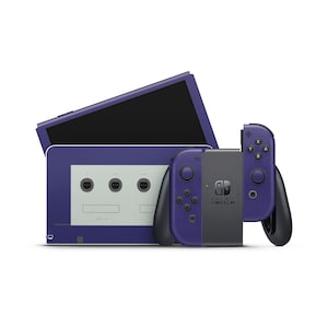 Puede incluir: Una consola Nintendo Switch morada con mandos Joy-Con a juego. La consola tiene un diseño inspirado en la GameCube, con un exterior morado y una placa frontal blanca con puertos para mandos de GameCube. Los Joy-Cons también son morados.
