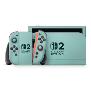 Peut inclure: Une console Nintendo Switch de couleur sarcelle avec des manettes Joy-Con assorties. Les manettes ont des boutons noirs et un accent corail. La console et les manettes présentent le logo Nintendo Switch et le chiffre "2".