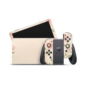 Könnte beinhalten: Eine Nintendo Switch-Konsole und Joy-Con-Controller mit floralem Design. Konsole und Controller haben einen cremefarbenen Hintergrund mit rosa Blüten und grünen Blättern. Die Joy-Con-Controller sind an den Seiten schwarz.