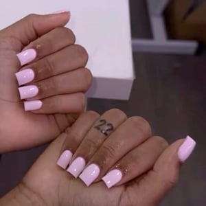 Pode incluir: Duas mãos com unhas quadradas rosa claro. Um pulso tem uma pulseira de prata. O outro pulso tem uma tatuagem que diz "90:12". O dedo indicador da outra mão tem uma tatuagem que diz "22".