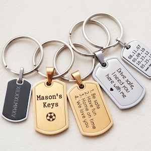 May include: Four metal dog tag keychains with split rings. One black tag with Roman numerals XII.XXI.MMXV. One gold tag with Mason's Keys and a soccer ball. One gold tag with a numbered list. One silver tag with Drive safe, I need you here with me and a heart. One silver tag with dates and best days ever.