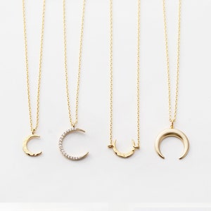May include: Three gold crescent moon necklaces with different styles. The first necklace has a hammered crescent moon pendant. The second necklace has a crescent moon pendant with small diamonds. The third necklace has a simple crescent moon pendant. The image also shows a card with the text "Crescent Moon" and "TOM DESIGN SHOP".
