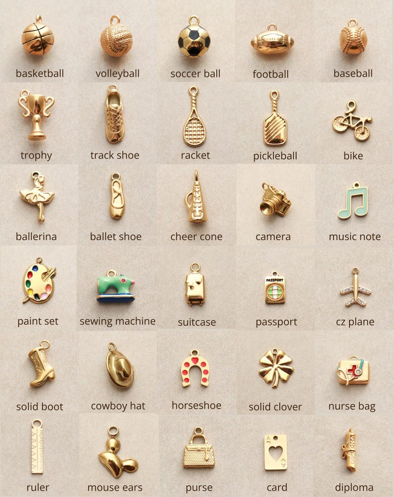 May include: A collection of gold-toned charms in various shapes, including sports equipment like a basketball and a soccer ball, along with other items such as a camera, a sewing machine, and a nurse bag. Each charm has a small loop for attaching to a bracelet or necklace.