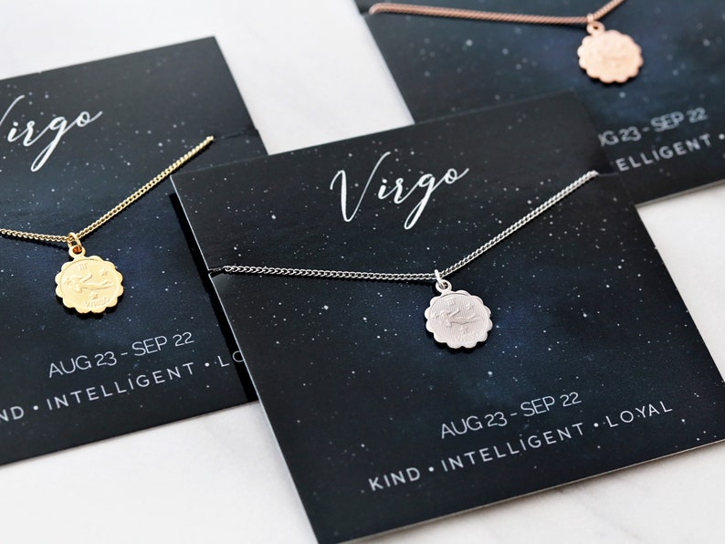 May include: Three necklaces with zodiac signs on a black background with stars. The necklaces are gold, silver, and rose gold. The signs are Virgo, with the dates August 23 - September 22 and personality traits listed below.