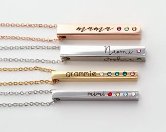 May include: Four personalized bar necklaces in rose gold, silver, and gold tones. Each bar features engraved text and colorful gemstones. The necklaces are displayed on a white background.