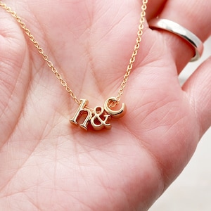 May include: A gold necklace with a pendant that says "h&c".