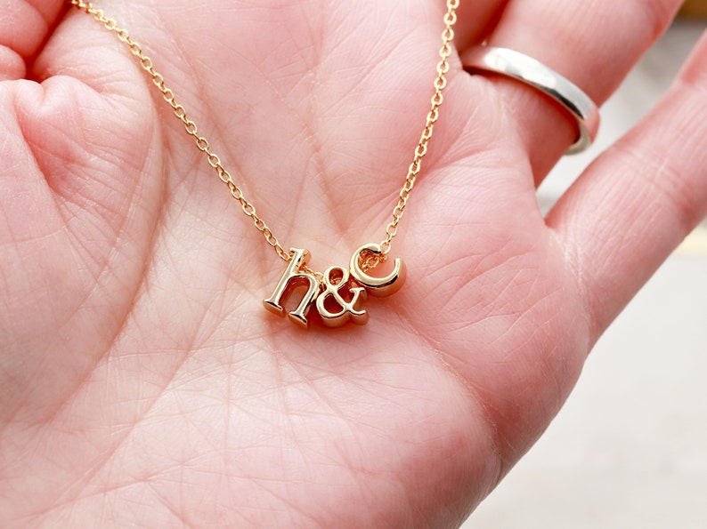 May include: A gold necklace with a pendant that says "h&c".