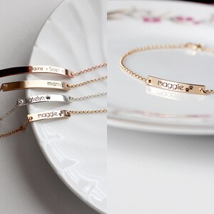 May include: Four gold, silver, and rose gold bracelets with personalized nameplates. The nameplates are engraved with the names "Maggie", "Katelyn", "mama", and "Claire - Sophia".
