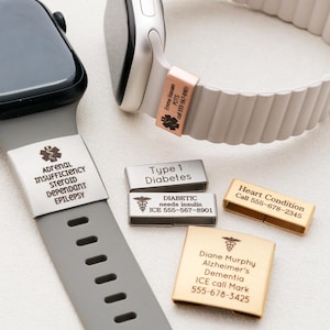 May include: Two smartwatches with medical alert bands attached, one grey and one beige. The grey band features a silver tag with medical text. The beige band has a rose gold tag. Three additional metal medical alert tags are shown in silver and gold.