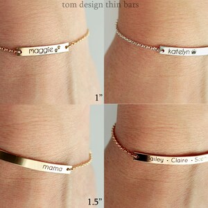 May include: Four gold and silver chain bracelets with personalized engraved bars. The bars are 1 inch, 1.25 inches, 1.5 inches, and 1.75 inches long. The bars are engraved with the names "Maggie", "Katelyn", "Mama", and "Bailey Claire Sophie".