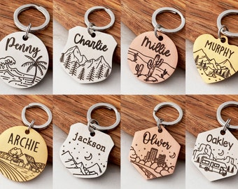 May include: Ten different keychains with various designs and names engraved on them. The keychains are made of metal and have a silver, gold, or copper finish. The designs include a beach scene, mountains, a cactus, a city skyline, and a camper van.