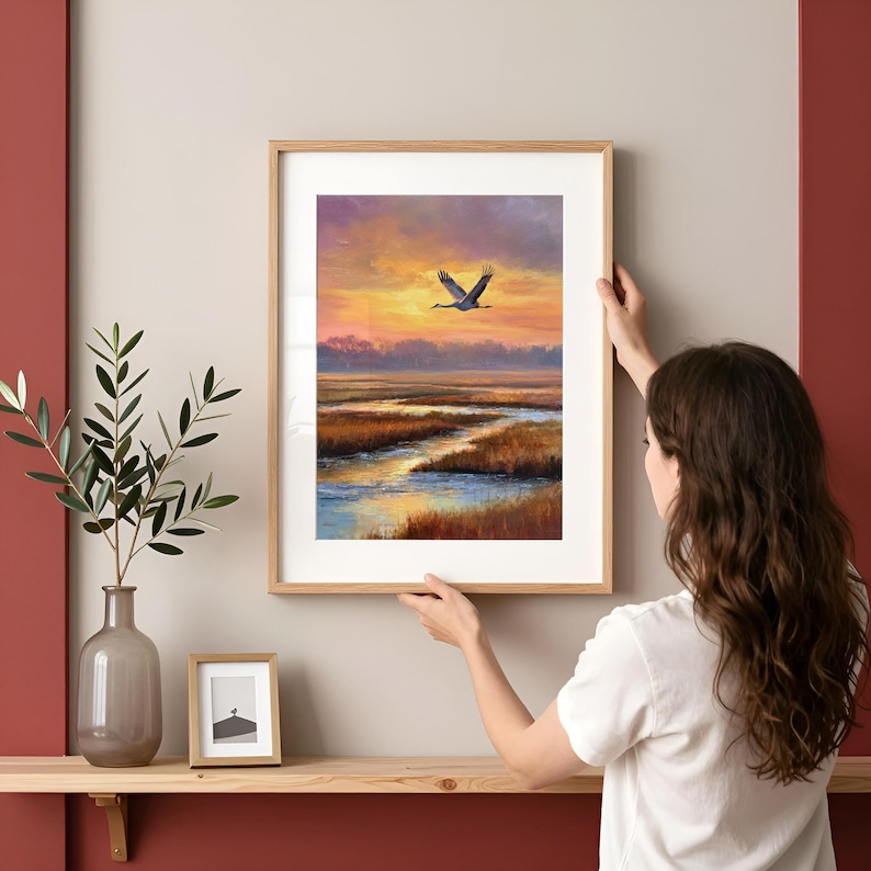 Mid-flight Sandhill Crane wall art for bedroom — calming nature-themed piece showcasing a dramatic sunset over soft waves and tidal channels.