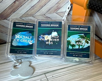 May include: Three clear plastic containers with wax melts inside. The wax melts are labeled "Sea Salt Ice Cream", "The World That Never Was", and "Destiny Islands". Each container is 2.5 ounces.