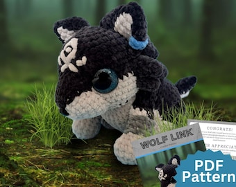 May include: A black and white crocheted plush toy resembling a wolf with large dark eyes, a white forehead marking, and a blue ear accent. Next to the plush is a document titled WOLF LINK Crochet Pattern with PDF Pattern text visible.