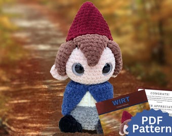 May include: A plush crochet doll featuring a dark red pointed hat, brown hair, large black eyes, a blue cape, and gray pants. Next to the doll is a document titled WIRT Crochet Pattern with a PDF Pattern badge, detailing the character design.