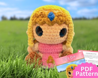 May include: A crocheted plush doll featuring yellow hair with a blue gem, large black eyes, and a pink outfit. Next to the doll is a document titled ZELDA Crochet Pattern with a pink starburst graphic containing the text PDF Pattern.