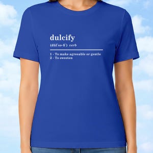 以下が含まれることがあります： ロイヤルブルーの半袖Tシャツ。白い文字で「dulcify (dŭl'sə-fī') verb 1 - To make agreeable or gentle 2 - To sweeten」とプリントされています。クルーネックで、標準的なフィット感とストレートな裾が特徴です。