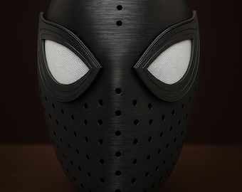 May include: A black, textured mask with a perforated design, reminiscent of a superhero's attire. The mask features white mesh eye coverings and a sleek, modern aesthetic. The mask is likely made of a durable material.