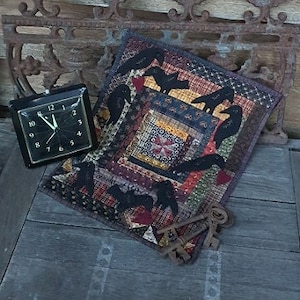 Può includere: Una trapunta colorata in patchwork con una silhouette nera di uccelli e un orologio su una superficie di legno.