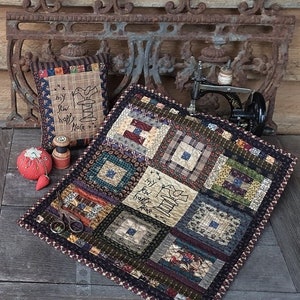 May include: A patchwork quilt with a variety of fabric squares in earth tones, featuring a pillow with the text "my sew happy place". A vintage sewing machine, pincushion, spools, and scissors complete the scene.
