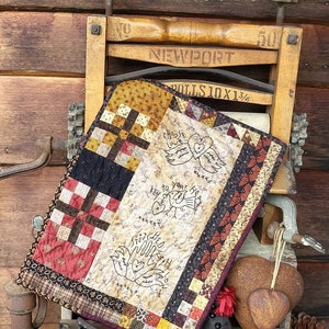 Może przedstawiać: Rusztykalna kołdra z patchworkowym wzorem i haftowanymi sercami. Kołdra jest wystawiona na antycznej drewnianej prasce do ubrań z widocznymi napisami "NEWPORT" i "ROLLS 10 X 13 1/4". Kołdra zawiera tekst "Choose Love" i "2" to your heart" oraz "Stitched with Love".