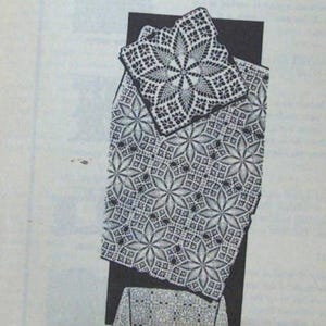 May include: A black and white crocheted doily and tablecloth set. The doily is square with a central starburst design. The tablecloth features a repeating floral pattern. The items are displayed on a black background.