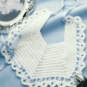 Puede incluir: Babero de bebé blanco de ganchillo con borde festoneado y una cinta de satén azul atada alrededor del cuello.