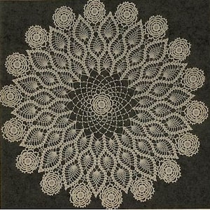 May include: A delicate white crochet doily with a floral design. The doily has a central starburst pattern surrounded by a ring of smaller flowers.
