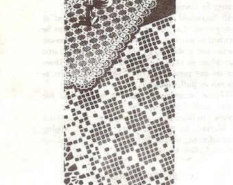 May include: A white crocheted table runner with a square pattern. The runner is laid on a table with a bowl of fruit in the center.