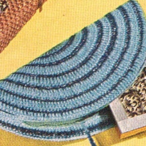 May include: A blue and white crocheted purse with a curved shape. The purse is closed and has a small, decorative box attached to it.