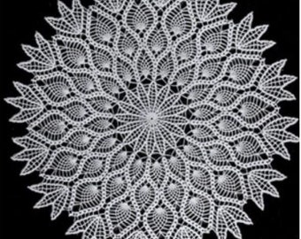May include: White crocheted doily with a circular design featuring intricate floral patterns.