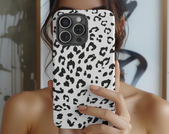 May include: A white and black leopard print phone case for an iPhone with a black camera lens cover.