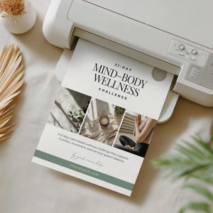 May include: A white printer printing a flyer with the text "21-DAY MIND-BODY WELLNESS CHALLENGE". The flyer includes images and the text "A 21-day, habit-based wellness challenge that supports nutrition, movement, and nervous system balance."