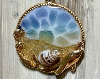 Resin beach pendant with real tiny shells in gold bezel