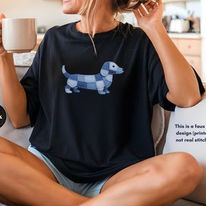May include: Black t-shirt featuring a blue and white patchwork dachshund design. The text on the image says, "This is a faux patchwork design (printed effect), not real stitched fabric."