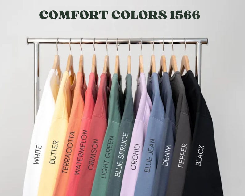 May include: A rack of 12 different colored sweatshirts, labeled with the names of the colors: White, Butter, Terracotta, Watermelon, Crimson, Light Green, Blue Spruce, Orchid, Blue Jean, Denim, Pepper, and Black. The rack is labeled "COMFORT COLORS 1566".