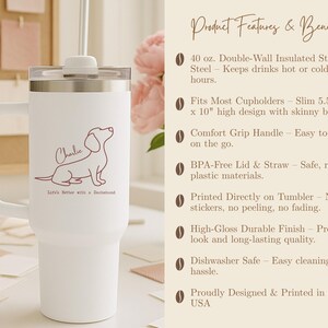 May include: White insulated tumbler with a handle, straw, and lid. It features a dachshund illustration and the name "Charlie" in a cursive font. Text on the tumbler reads "Life's Better with a Dachshund."