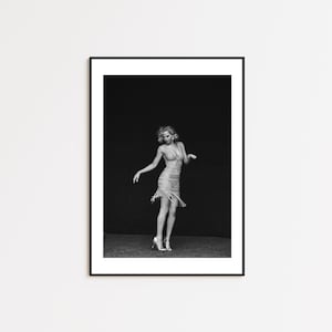 May include: A black and white photograph of a woman wearing a sequined dress and posing in a studio setting.