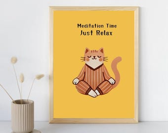 May include: A framed print with a yellow background features a cartoon cat in a meditative pose. The cat wears a brown and white striped outfit. The text "Meditation Time Just Relax" is at the top of the print. The frame is made of light-colored wood.