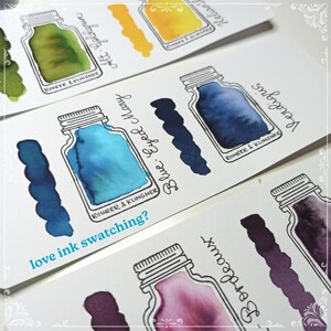 May include: Ink swatches on white cards, featuring various colors like blue, yellow, and green. Each swatch is accompanied by a drawing of an ink bottle and the ink's name. The text "love ink swatching?" is visible.